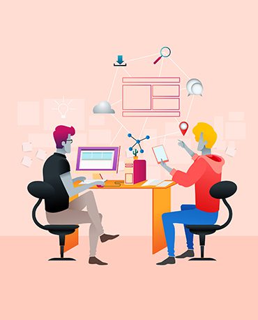 Two people sitting at a table with computers.