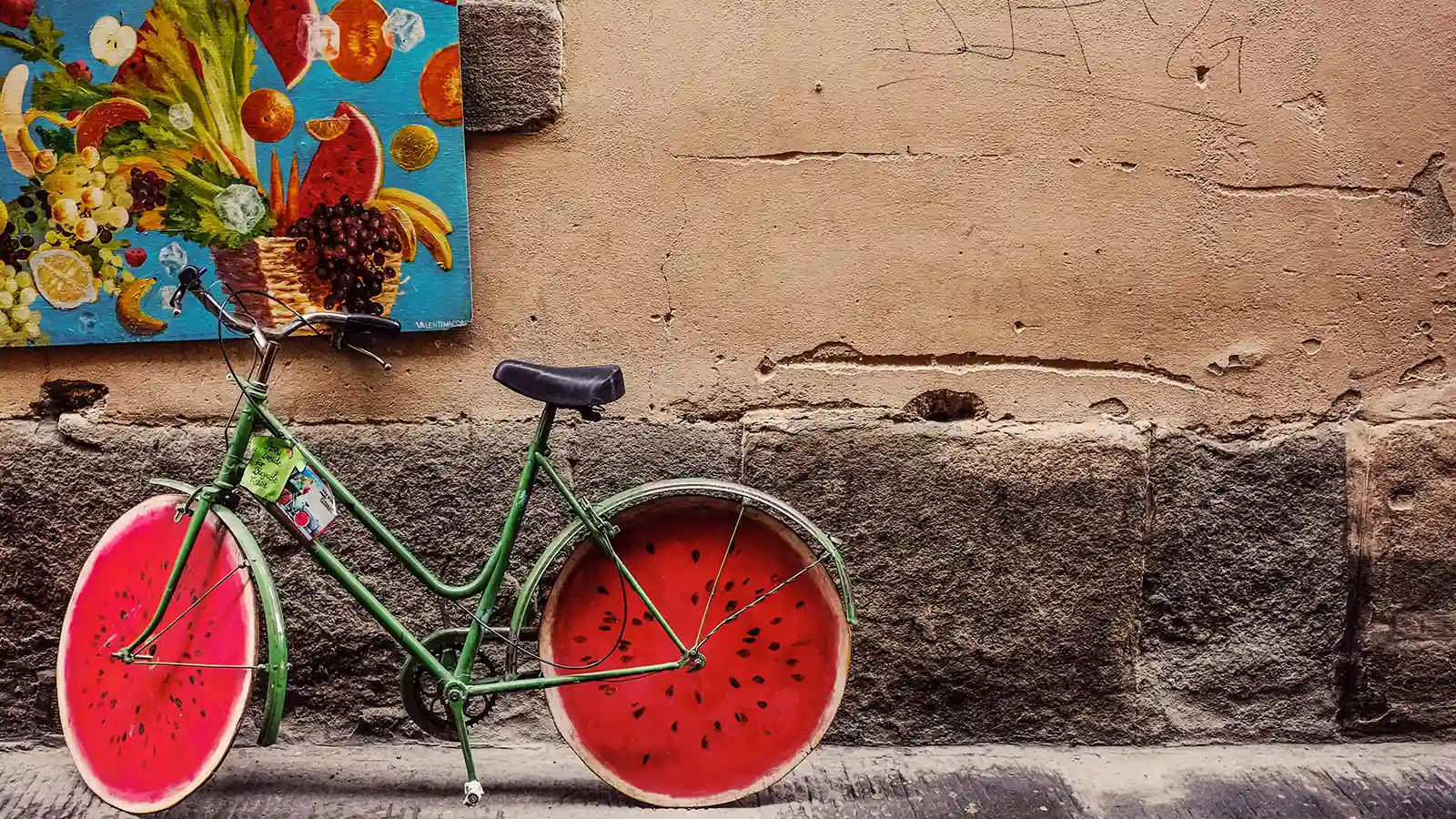 Model of a cycle that has its wheels made of watermelon