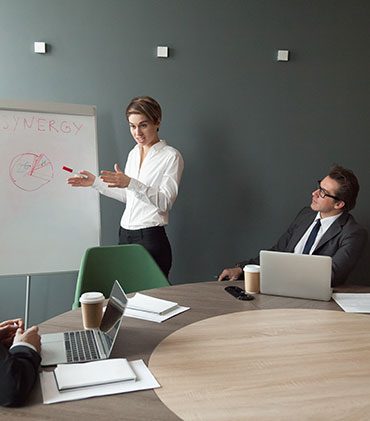 A woman standing at the front of a room