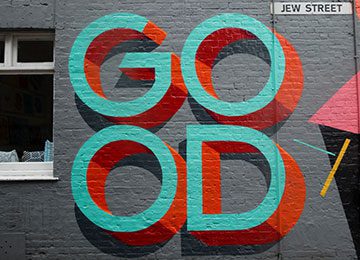 A wall with the word good painted on it.