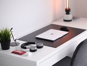 A desk with a laptop and headphones on it
