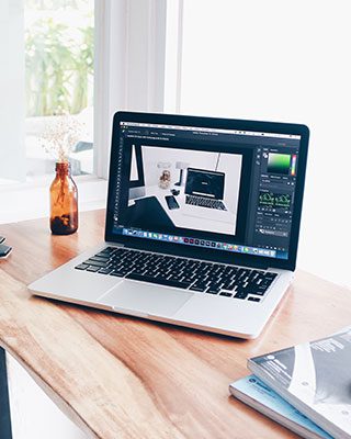 A laptop sitting on top of a wooden table.