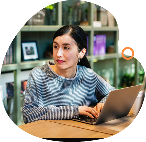 A woman sitting at a table with a laptop.