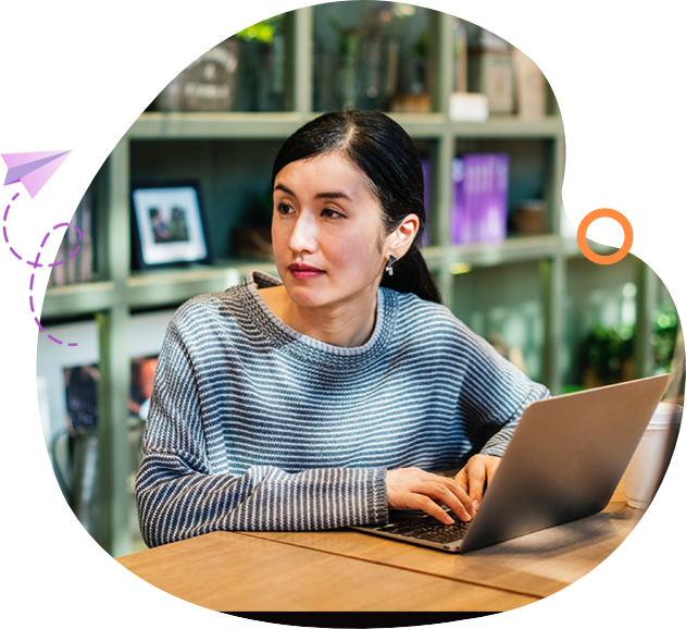 A woman sitting at a table with a laptop.
