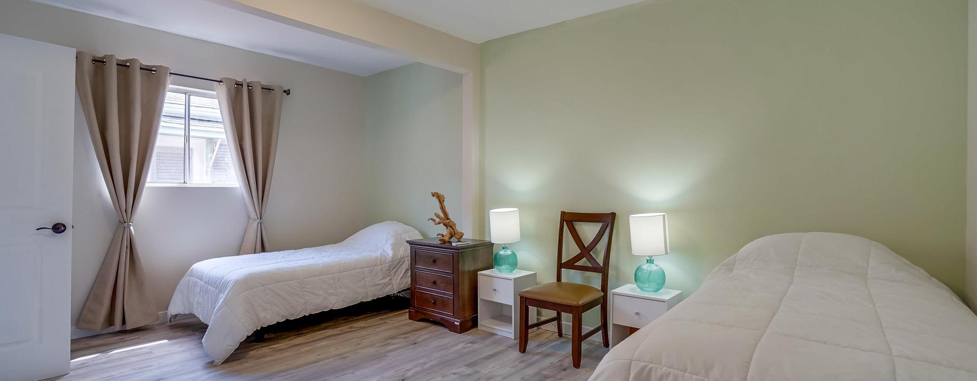 A bedroom with two beds and a desk in it