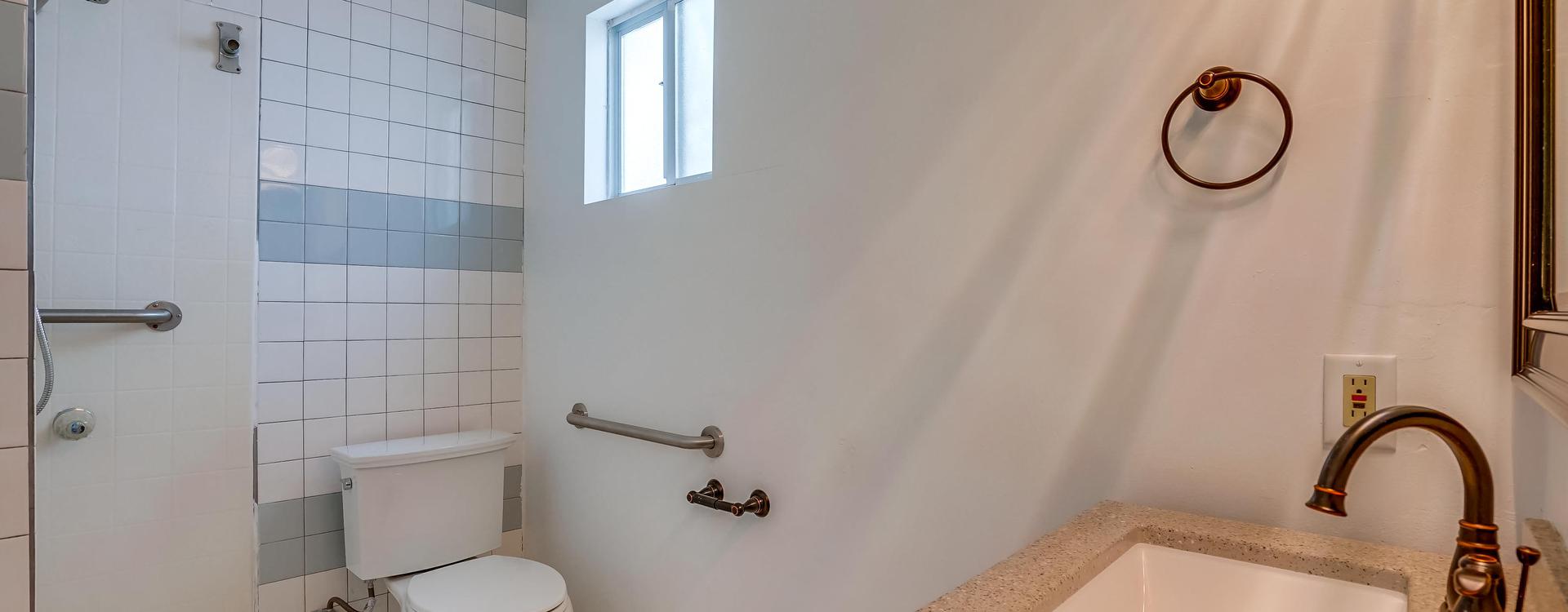 A bathroom with white walls and a toilet.