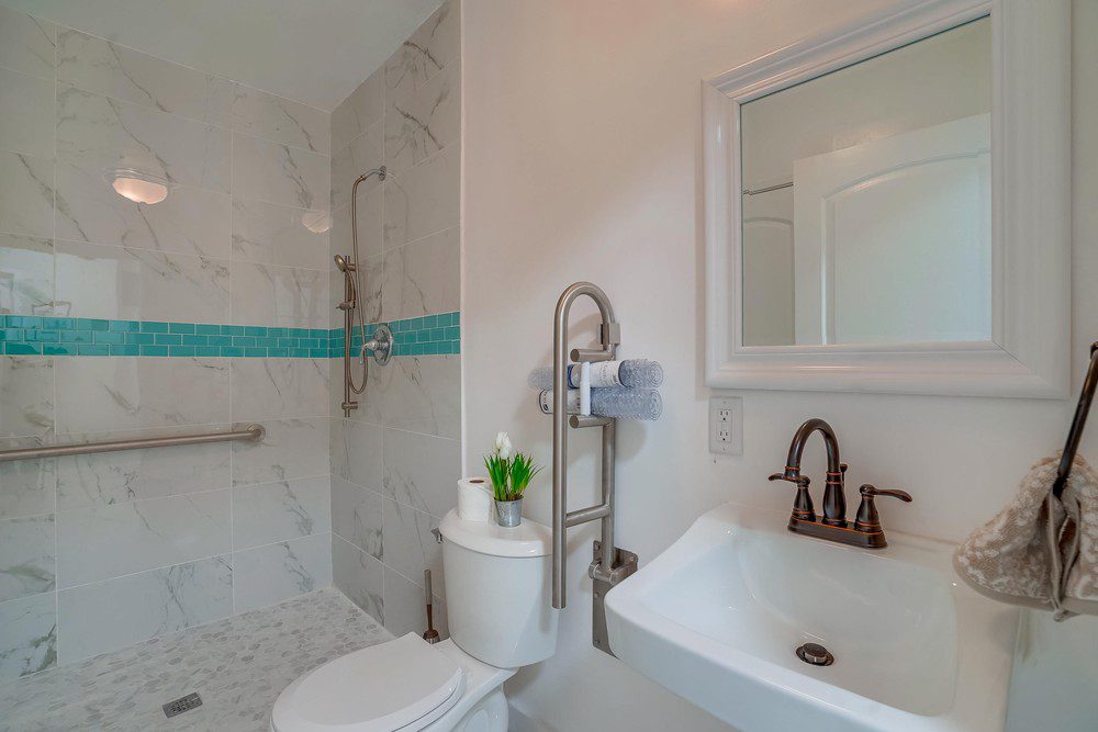 A bathroom with a toilet, sink and mirror.