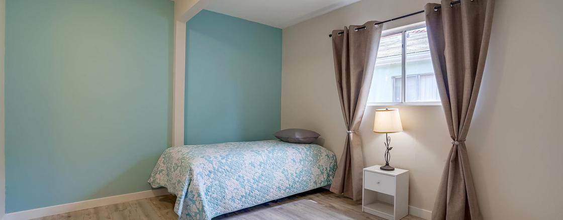 A bedroom with a bed and nightstand in it