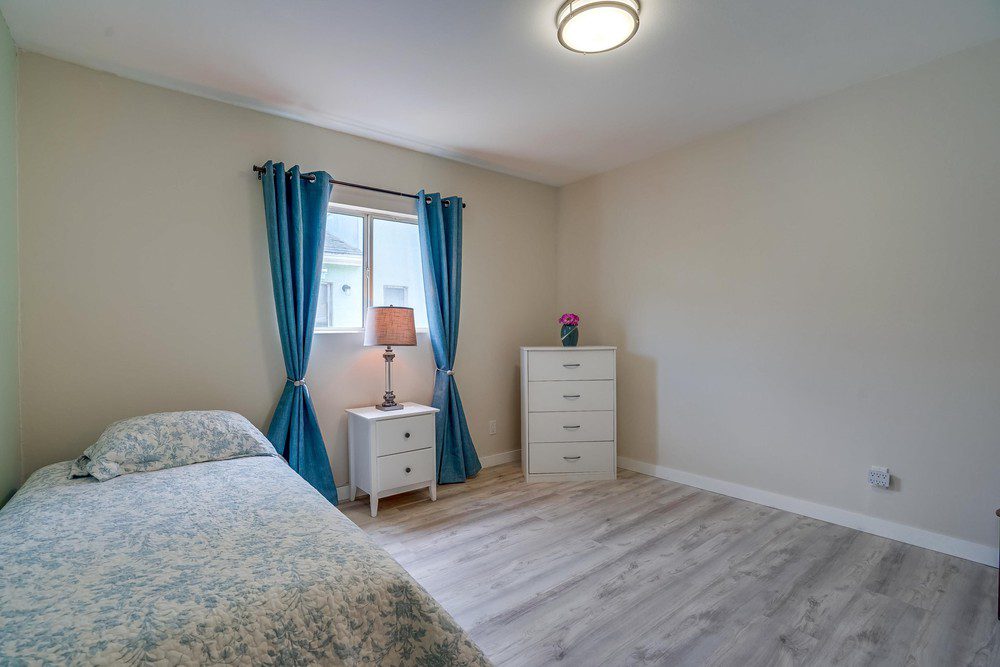 A bedroom with two beds and a dresser.