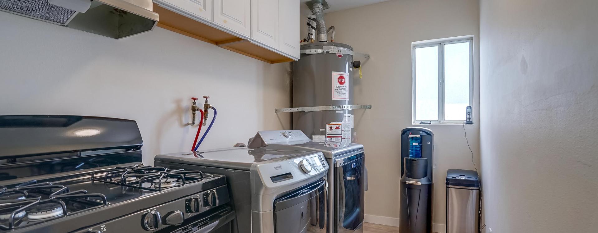 A kitchen with two ovens and a water heater.