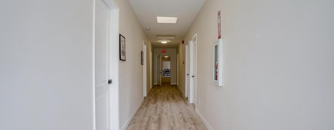A hallway with two doors and a light on the wall.