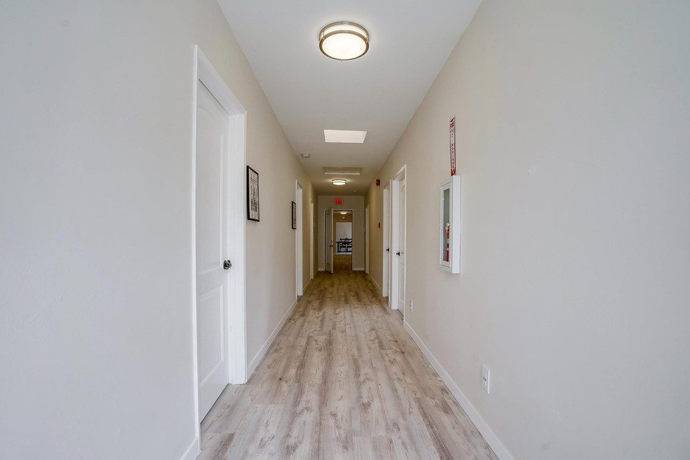 A hallway with two doors and a light on the wall.