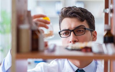Man examining shelves with medications.